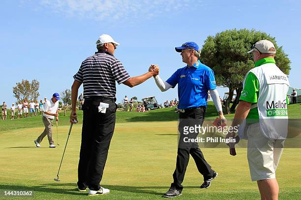 Gary Wolstenholme of England is congratulated by Mike Harwood of Australia on the 18th hole during the final round of the Mallorca Open Senior played...