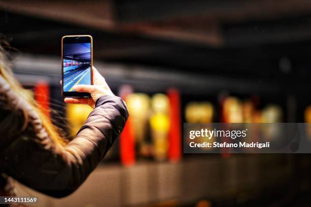 smartphone in hand with subway in the background - metro screen door stockfoto's en -beelden