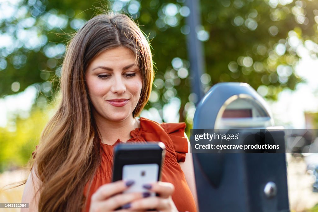 Weiße und hispanische Amerikanerin in Kleinstadt Amerika Downtown Parking Lot District mit Kreditkarten und elektronischen Geräten Zahlungen für unterwegs Fotoserie