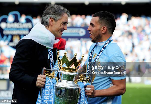 Roberto Mancini the manager of Manchester City and Carlos Tevez of Manchester City celebrate with the trophy following the Barclays Premier League...