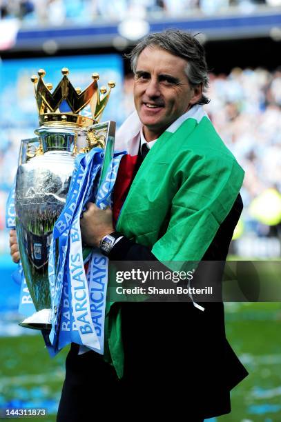 Roberto Mancini the manager of Manchester City celebrates with the trophy following the Barclays Premier League match between Manchester City and...