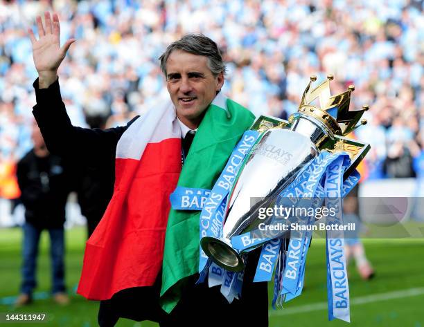 Roberto Mancini the manager of Manchester City celebrates with the trophy following the Barclays Premier League match between Manchester City and...