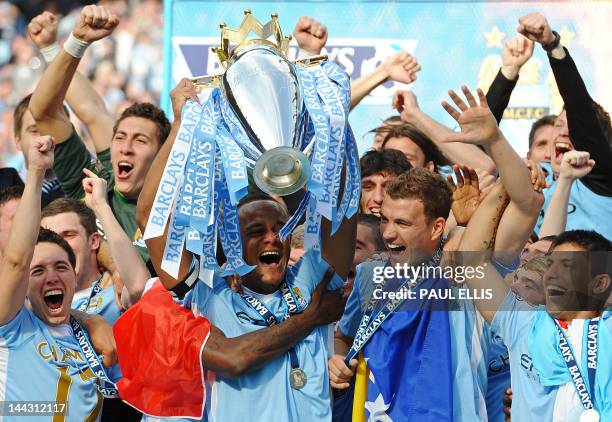 Manchester City's Belgian captain Vincent Kompany lifts the Premier league trophy, and celebrates with Bosnian striker Edin Dzeko , Argentinian...