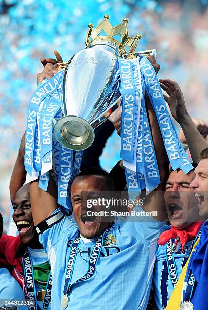 Vincent Kompany the captain of Manchester City lifts the trophy following the Barclays Premier League match between Manchester City and Queens Park...