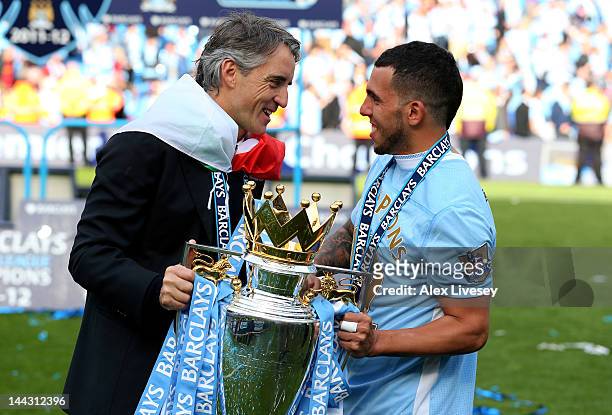 Roberto Mancini the manager of Manchester City and Carlos Tevez of Manchester City celebrate with the trophy following the Barclays Premier League...