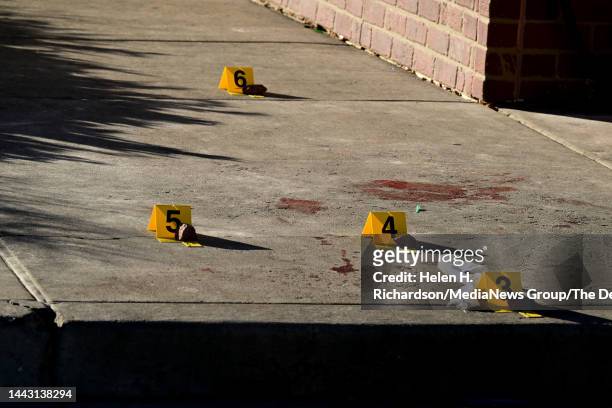 Evidence markers are placed at the scene near a 7-11 where a victim was found near Club Q on November 20, 2022 in Colorado Springs, Colorado. An...