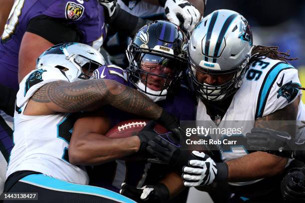 Running back Kenyan Drake of the Baltimore Ravens is tackled by defensive tackle Bravvion Roy of the Carolina Panthers in the fourth quarter at M&T...