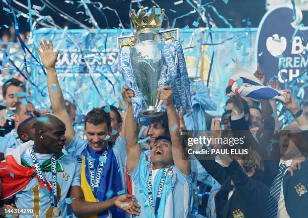 Manchester City's Argentinian striker Sergio Aguero lifts the Premier league trophy after their 3-2 victory over Queens Park Rangers in the English...