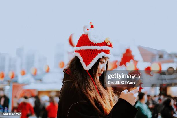 asian young woman celebrating chinese new year using smartphone on the street - shanghai calling stock pictures, royalty-free photos & images