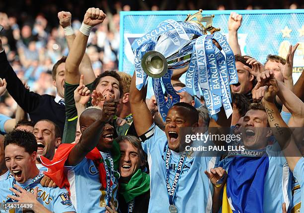 Manchester City's Belgian captain Vincent Kompany lifts the Premier league trophy after their 3-2 victory over Queens Park Rangers in the English...