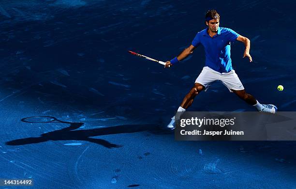 Roger Federer of Switzerland slides to play a backhand to Tomas Berdych of the Czech Republic in his final match during the Mutua Madrilena Madrid...