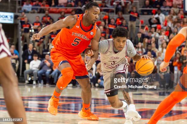 Henry of the Texas Southern Tigers looks to maneuver the ball by Chris Moore of the Auburn Tigers at Neville Arena on November 18, 2022 in Auburn,...