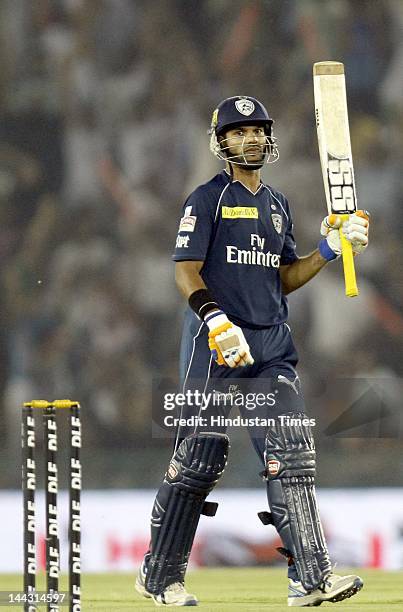 Deccan Chargers batsman Shikhar Dhawan raises his bat after completing his half century during the IPL T20 cricket match played between Kings XI...
