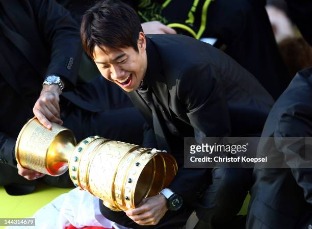 Shinji Kagawa of Dortmund catches the trophy during a parade at Borsigplatz celebrating Borussia Dortmund's Bundesliga and DFB Cup win on May 13,...