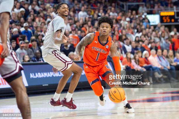 Wendell Green Jr. #1 of the Auburn Tigers dribbles the ball by John Walker III of the Texas Southern Tigers at Neville Arena on November 18, 2022 in...