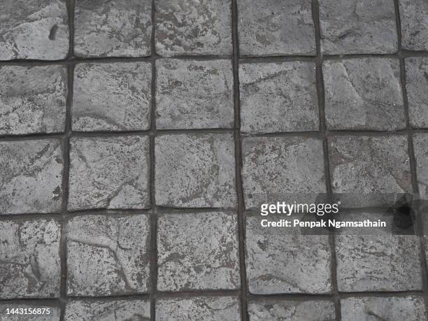 stamp concrete black grey color hardener printing patterns on the cement or mortar surface block shape square pattern material rough texture background - stamped concrete stockfoto's en -beelden