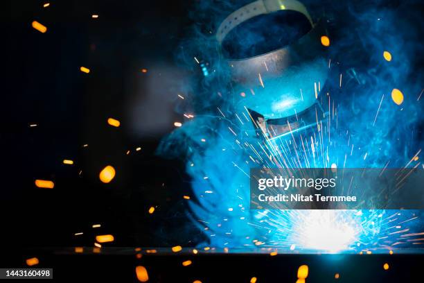 building and development of labor skills in the construction industry. front view of african american welder working in a metal manufacturing facility to build structures, equipment, and construction metal components. - steelmaking stock pictures, royalty-free photos & images