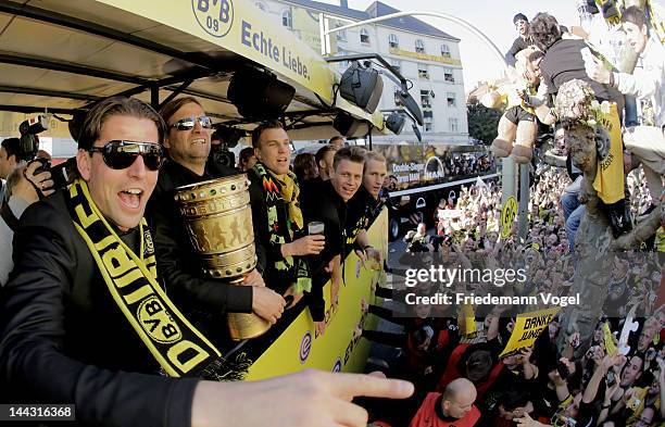 Roman Weidenfeller, Head coach Juergen Klopp and Kevin Grosskreutz of Borussia Dortmund celebrate during a victory parade on an open top bus after...