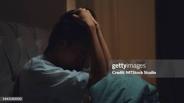 sad depressed asian girl in bed. lonely person with stress, insomnia and trouble sleeping. - low self esteem stock pictures, royalty-free photos & images