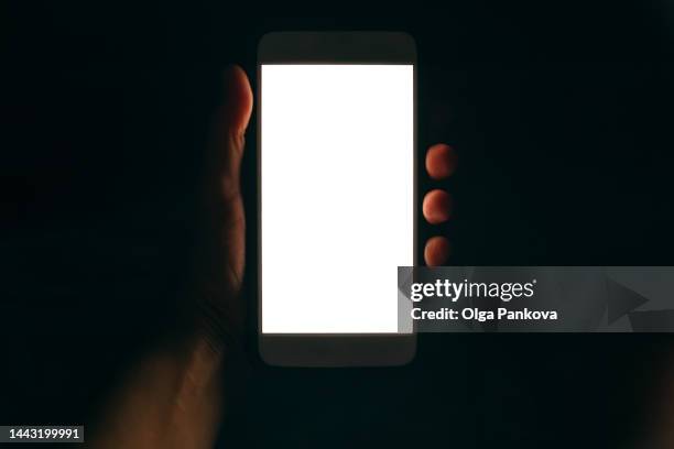 phone with white screen in human hand in the dark - projection screen night stock pictures, royalty-free photos & images