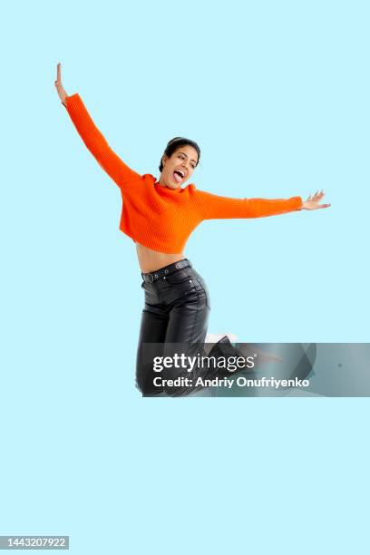 young adult female jumping for joy - jumping casual clothing studio shot stock pictures, royalty-free photos & images