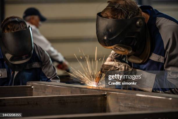 schweißer, die in der fabrik arbeiten - metalwork stock-fotos und bilder
