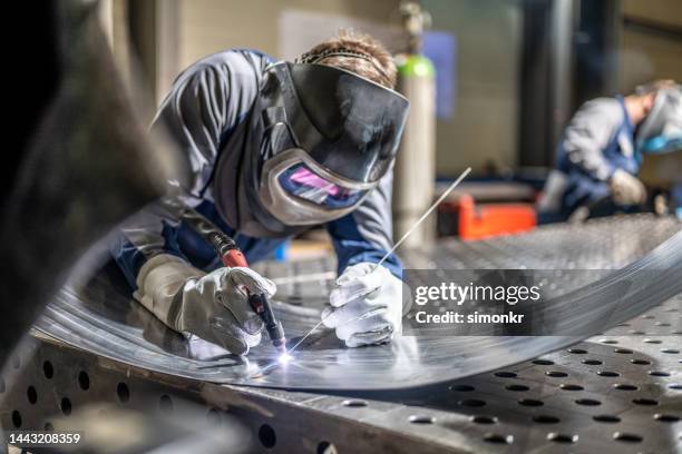 welder welding sheet metal - maken stockfoto's en -beelden