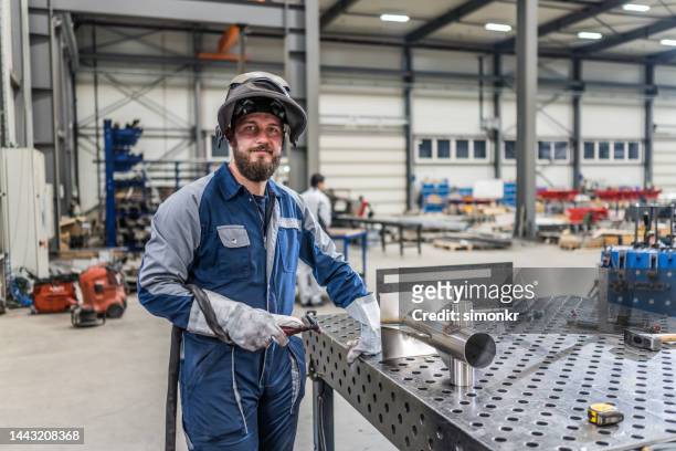 welder standing in factory - trestles stock pictures, royalty-free photos & images
