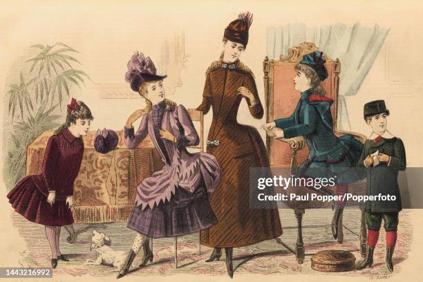 Colour plate from Journal Des Demoiselles showing a group of children wearing smart coats and suits, the older girls wear longer line brown and...