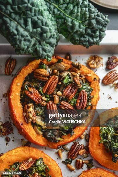 roasted pumpkin filled with kale, pecan nuts and seeds. - stuffing food stock pictures, royalty-free photos & images