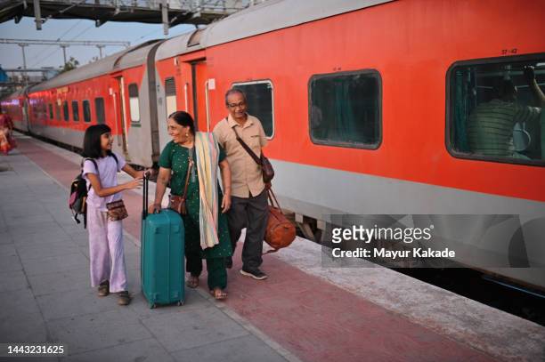 girl ready to board a train while going on vacation with her grandparents - india train stock-fotos und bilder
