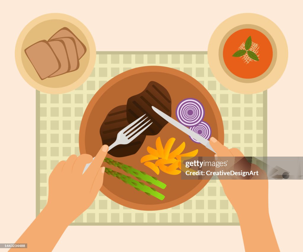Draufsicht der Hände mit Gabel und Messer, Fleischteller, Suppe und Brot