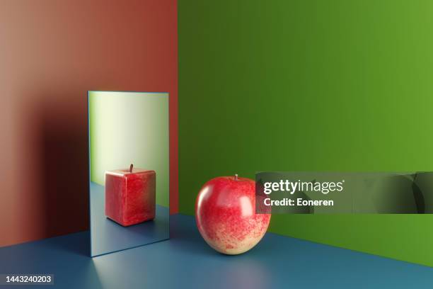 una manzana en un espejo que refleja la versión en forma de cubo de sí mismo - imagen distorsionada fotografías e imágenes de stock