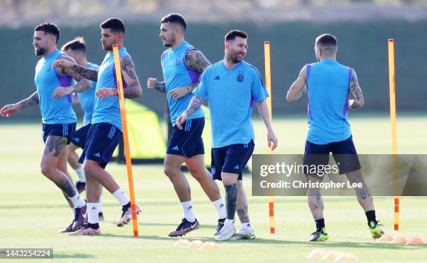 Lionel Messi of Argentina warms up with teammates during the Argentina Training Session at Qatar University training facilities on November 21, 2022...