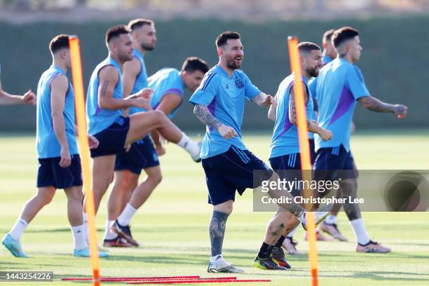 Lionel Messi of Argentina warms up with teammates during the Argentina Training Session at Qatar University training facilities on November 21, 2022...