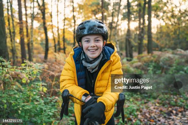 portrait of a young female cyclist in the forest - down coat stock pictures, royalty-free photos & images