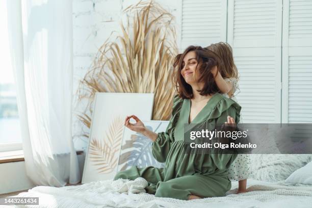 disturbing the peace and time to get away from all deals. calm, wise pregnant mother spend time with little daughter, who is playing with mom hair - little kids belly imagens e fotografias de stock