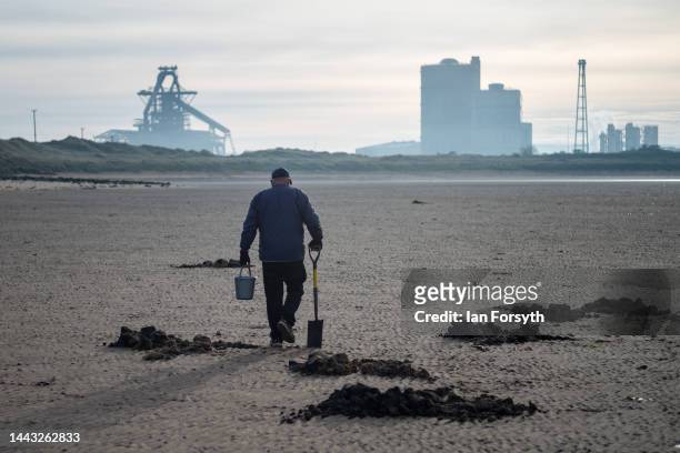 Man digs for fishing bait on the beach in front of the former steel blast furnace near Redcar that is due to be brought down in an explosive...