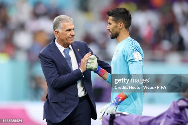 Carlos Queiroz, Head Coach of IR Iran, bumps fists with Hossein Hosseini as they are substituted into the game during the FIFA World Cup Qatar 2022...