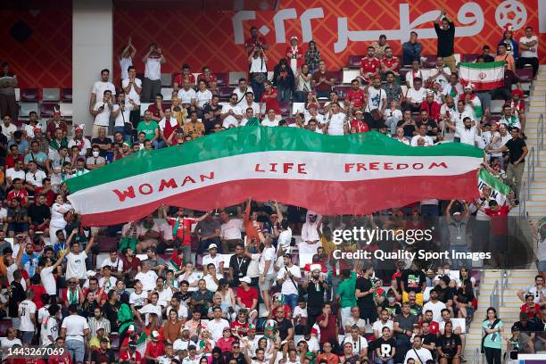 Iranian fans hold up signs "Woman Life Freedom" during the FIFA World Cup Qatar 2022 Group B match between England and IR Iran at Khalifa...