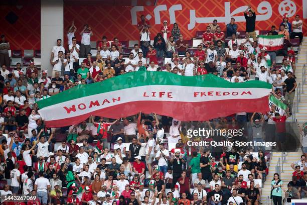 Iranian fans hold up signs "Woman Life Freedom" during the FIFA World Cup Qatar 2022 Group B match between England and IR Iran at Khalifa...