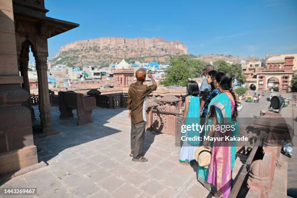 multi-generation family tourists visiting a clock tower, jodhpur - indian tour guide stock pictures, royalty-free photos & images