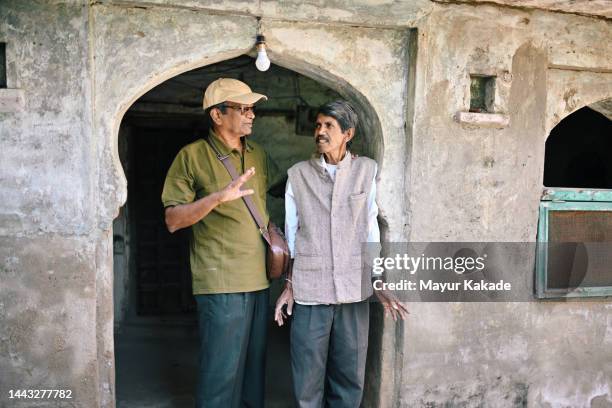 senior man tourist talking to a local guide in rajasthan - indian tour guide stock pictures, royalty-free photos & images