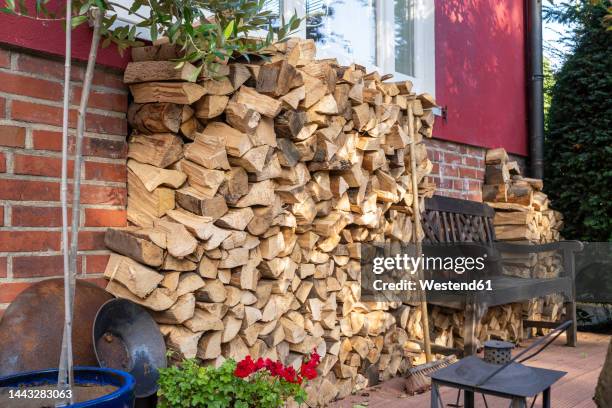stack of firewood stored in back yard - holzstapel stock-fotos und bilder