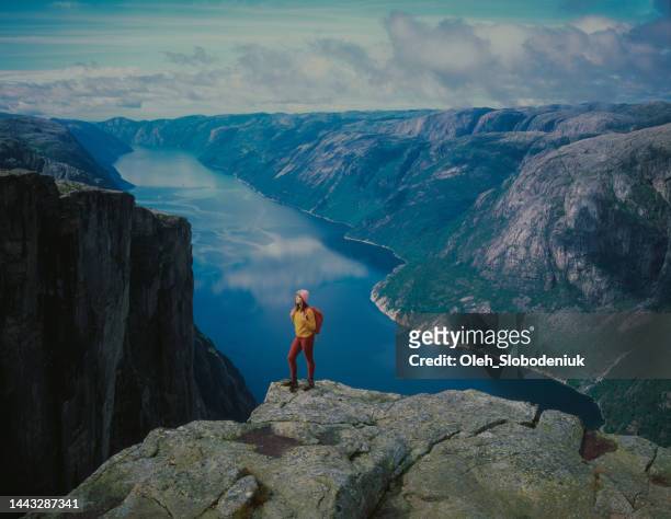 woman hiking in mountains on the background of lysefjorden - fjord stock pictures, royalty-free photos & images