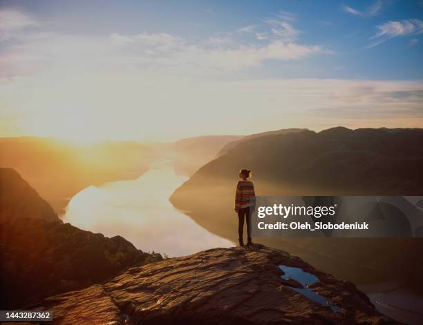 mujer caminando en las montañas en el fondo de lysefjorden - ideas brillantes fotografías e imágenes de stock