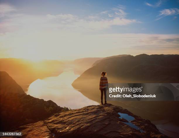 woman hiking in mountains on the background of lysefjorden - journey stockfoto's en -beelden