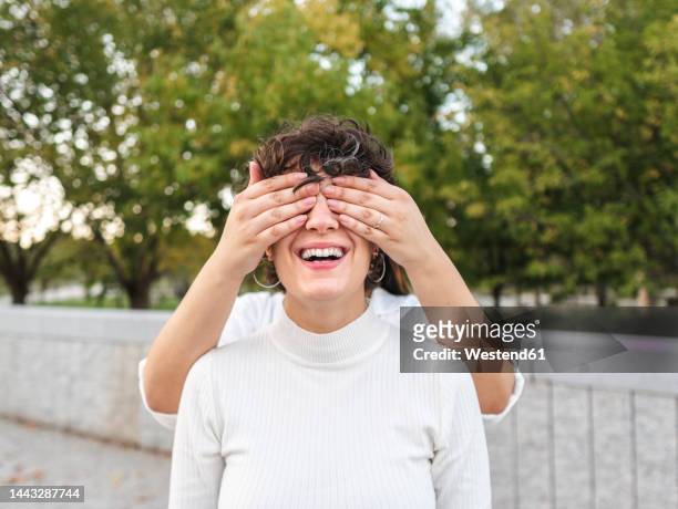 lesbian woman covering eyes of girlfriend - covering eyes stockfoto's en -beelden