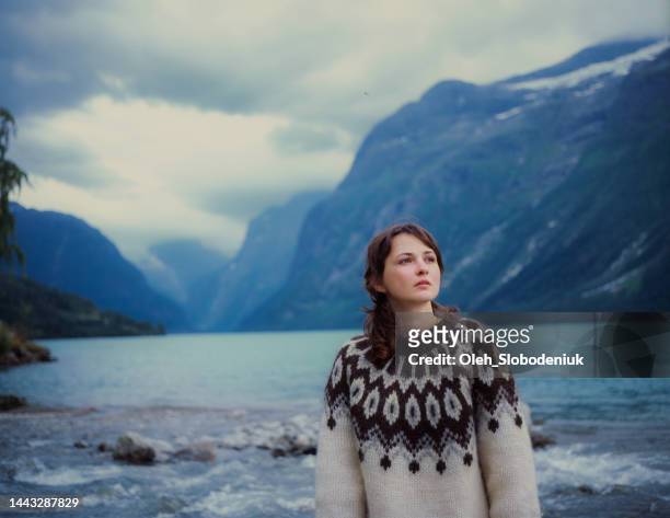frau im pullover geht in der nähe des sees in norwegen - traditionally norwegian stock-fotos und bilder