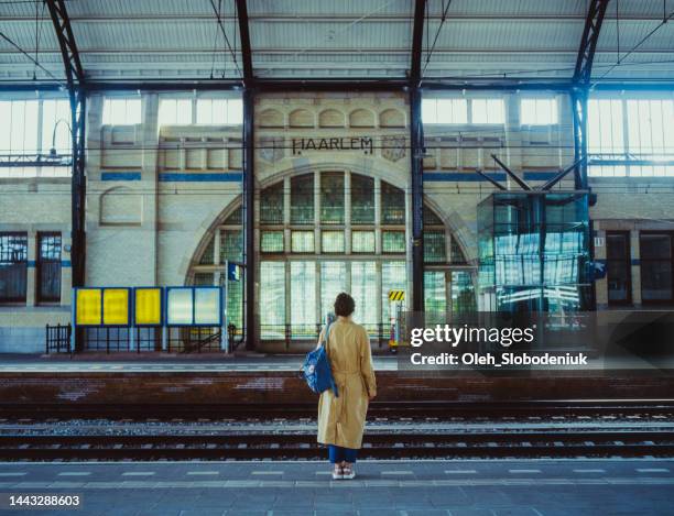femme attendant le train à la gare - quai photos et images de collection